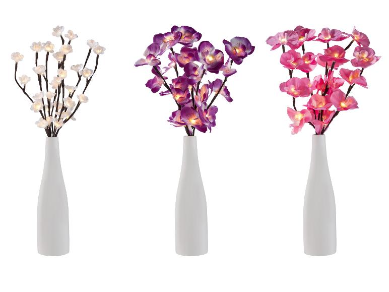 Trois vases blancs avec des fleurs lumineuses : blanches, violettes et roses.