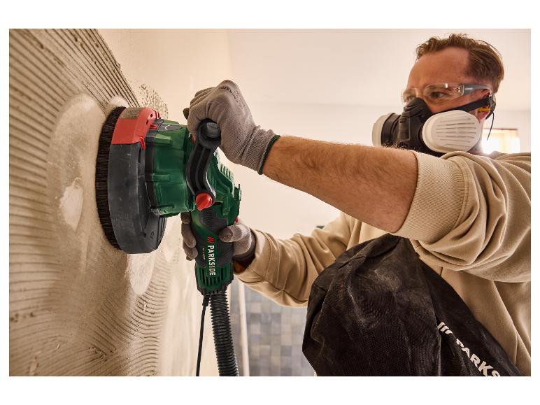 Un homme utilise une ponceuse Parkside pour lisser un mur.