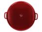 Plat de cuisson rond rouge avec poignées, vue du dessous, montrant les symboles d'entretien.