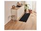 Un tapis de cuisine noir avec un motif de couverts sur un sol en bois.