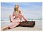 Combinaison pantalon et chemise en gaze de coton rose sur une plage.