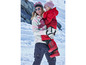 Une femme et une fille portent des vêtements d'hiver, dont une veste rose et des bottes de neige rouges.