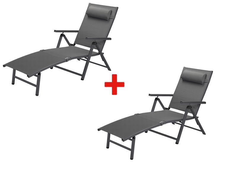 Deux chaises longues pliantes en aluminium gris.