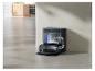 Aspirateur robot noir avec station de vidage automatique dans une cuisine moderne