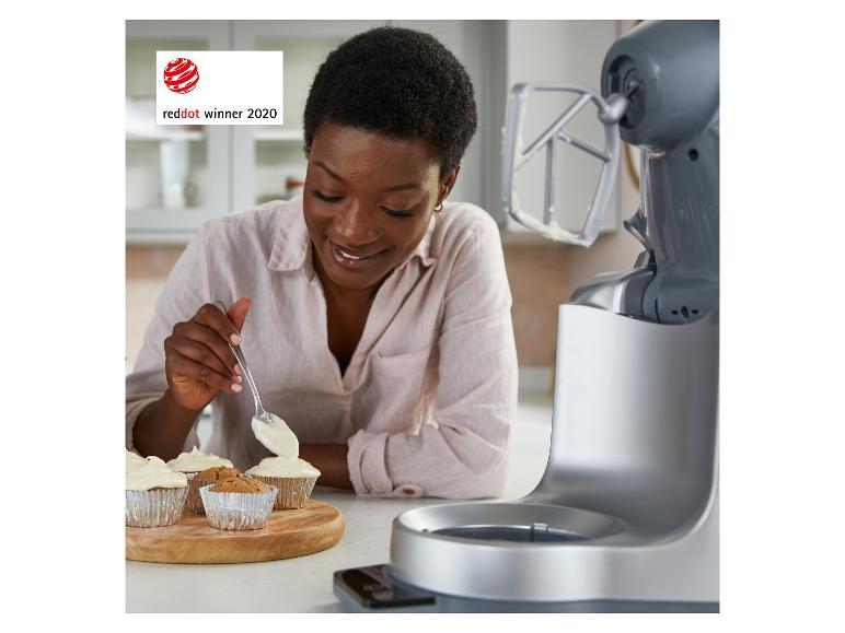 Femme décorant des cupcakes, avec un robot pâtissier à côté. Prix Red Dot 2020.
