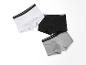 Trois paires de boxers en blanc, noir et gris.