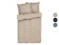 Parure de lit beige avec oreillers.