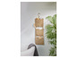 Trois paniers de rangement tissés avec des accessoires de salle de bain sur un mur blanc.