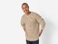 Un homme portant un pull beige à manches longues