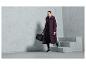 Une femme portant un long manteau d'hiver violet et un sac de sport noir.