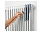 Peinture d'un radiateur blanc en gris avec un pinceau
