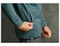 Un homme portant une veste bleue avec une fermeture éclair et une ceinture noire.