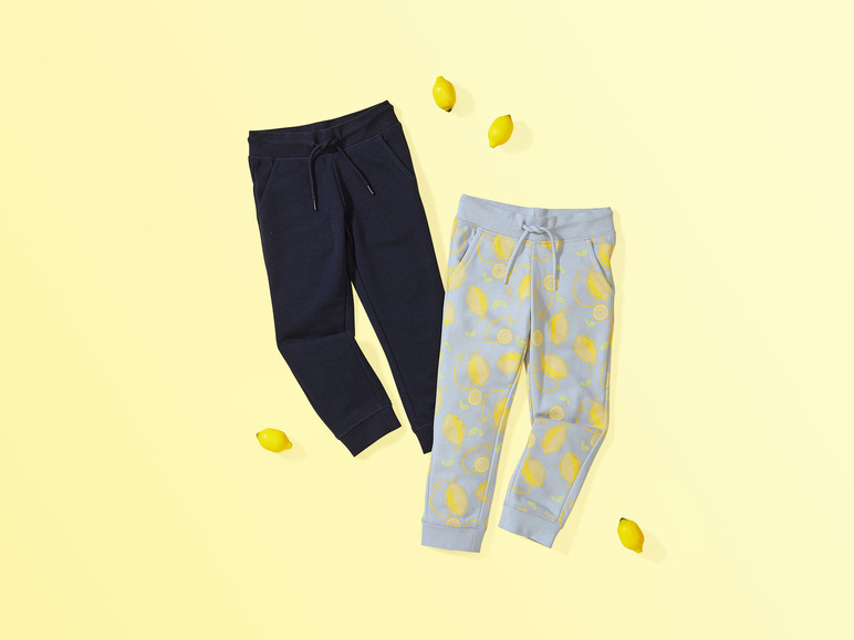 Deux pantalons de survêtement, un bleu foncé et un bleu clair avec des citrons.