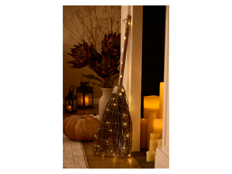 Balai de sorcière lumineux d'Halloween avec citrouille et lanternes.