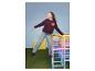 Fille en jean wide leg ESMARA KIDS et sweat bordeaux sur une structure d'escalade colorée