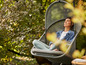Une femme se détend dans un fauteuil suspendu dans le jardin.