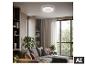 Ventilateur de plafond avec lumière dans un salon moderne avec canapé et plantes.