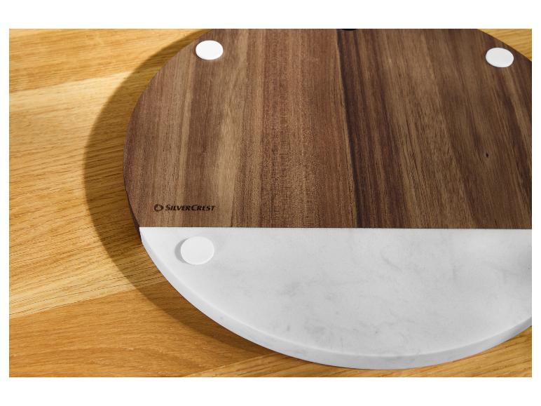 Planche ronde en bois et marbre SilverCrest sur une table en bois.