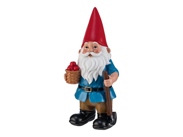 Nain de jardin avec un chapeau rouge, une chemise bleue, un panier de pommes et une pelle.
