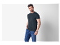 Homme en t-shirt gris foncé et jeans.