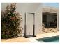 Douche extérieure avec cadre noir et base en bois à côté d'une piscine et de plantes vertes.