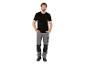 Homme en t-shirt noir et pantalon de travail gris.