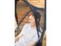 Un homme se détend dans une chaise de jardin en maille noire.