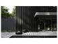 Terrasse extérieure moderne avec mobilier noir et plantes vertes.