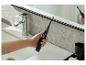 Une main tenant une brosse à dents électrique oclean dans une salle de bain.
