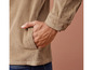 Une veste en velours côtelé beige avec une main dans la poche.