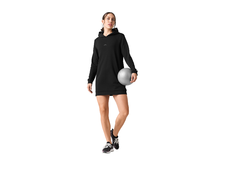 Femme portant une robe sweat-shirt noire et un ballon de pilates.