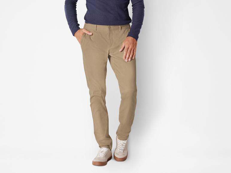 Pantalon chino beige avec des baskets blanches.