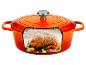 Cocotte en fonte orange avec un poulet rôti, de l'ail et des herbes à l'intérieur.