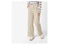 Pantalon large beige et baskets blanches.