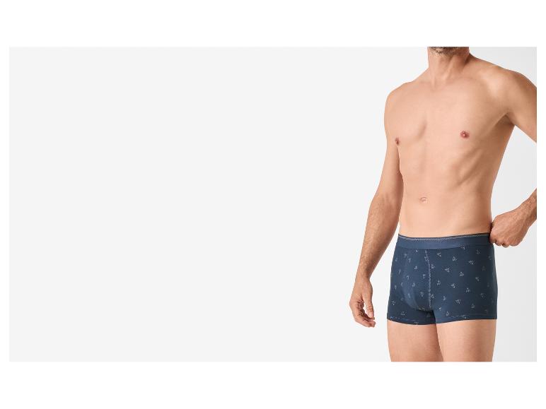 Homme portant un boxer bleu foncé avec un motif géométrique subtil.