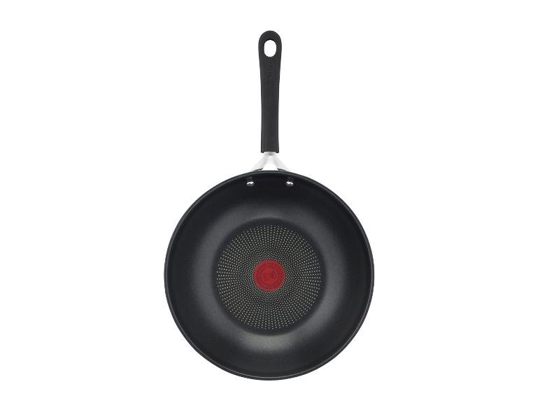 Wok noir avec poignée et indicateur de température rouge au centre.