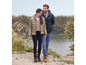 Une femme et un homme portent des doudounes en marchant le long d'un lac.
