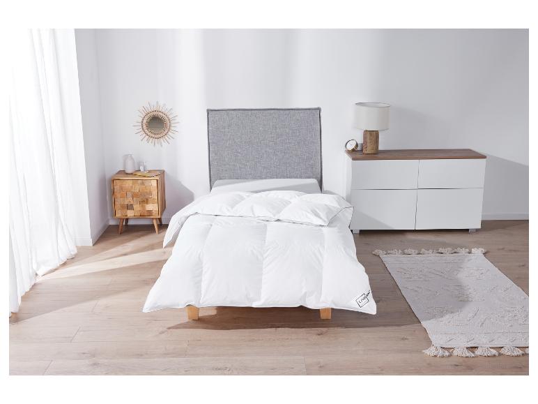 Une couette blanche de Livarno Living sur un lit dans une chambre à coucher.
