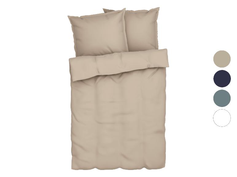 Parure de lit beige avec oreillers.