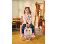 Fillette en veste rose et jean, tenant un sac à dos licorne.