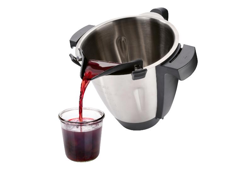 Un liquide rouge est versé d'une casserole dans un pot en verre.
