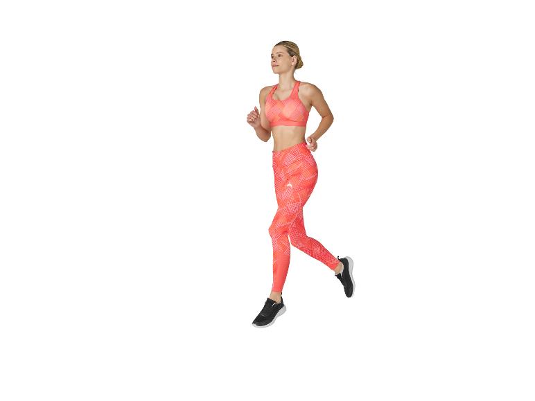 Femme en haut de sport et legging orange courant.