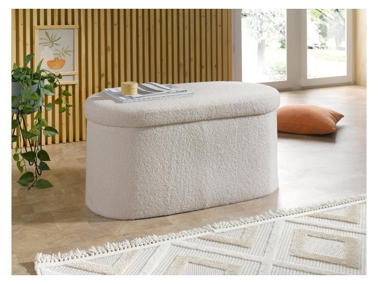 Un pouf ovale moelleux avec des magazines et une boîte décorative.