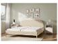 Cadre de lit beige avec un matelas blanc dans une chambre moderne.