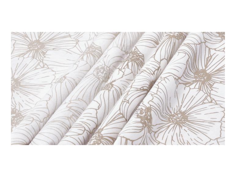 Tissu blanc à motif floral beige, disposé en plis.