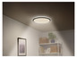 Un luminaire de plafond rond avec éclairage LED dans un salon moderne.