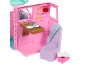 Camping-car jouet rose avec table à manger, siège et accessoires.