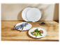 Trois assiettes blanches Corelle sur une table en bois avec de la nourriture et des couverts.