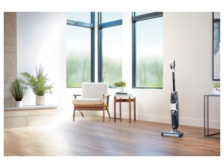 Aspirateur Bissell CrossWave dans un salon lumineux avec parquet.