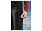 Pantalon noir avec fermeture éclair sur la poche sur fond de sommets montagneux.